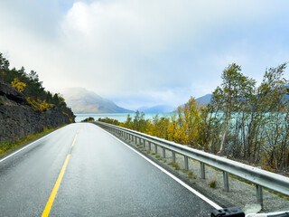 A motorhome parked by the road in the autumn landscape of the Lyngen Alps, Northern Norway, with mountains.