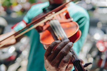 Busker group of men playing violin music instrument to entertain people.