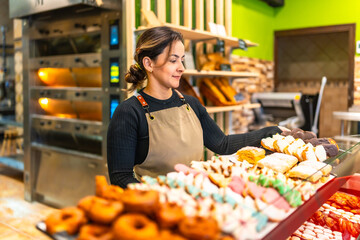 Woman selling bread and pastries in an artisan bakery