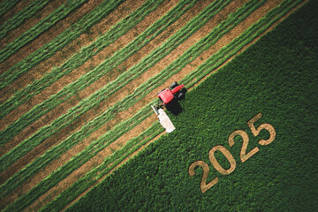 2025 Happy New year agriculture concept red tractor mowing green field