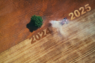 2025 Happy new year concept of aerial view on the combine working on the large wheat field
