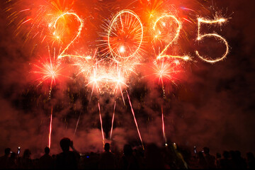 New year 2025 fireworks in night sky and party people crowd, bengal sparkles illumination