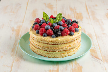 Homemade cake with fresh berries on wooden background.