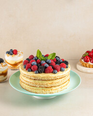 Homemade cake with fresh berries and sweet desserts on table.