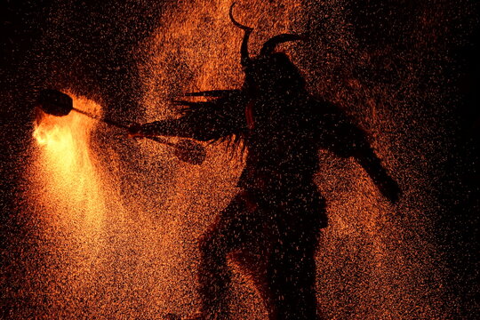 Rauhnachtbrauchtum. Als Teufel verkleidete Menschen tanzen im Funkenregen