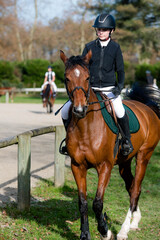 Close-up of a beautiful young rider and her mare in competition attire