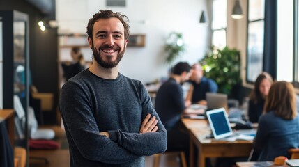Obraz premium Smiling man in modern office space with coworkers in background