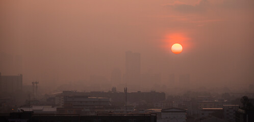 Golden sunset over a hazy urban skyline at dusk