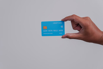 Person's hand showing the front of a credit card or debit card with blue color.