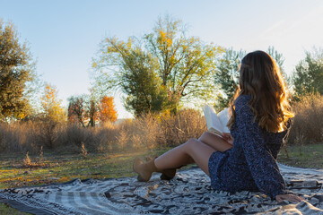 woman reading a book sitting in nature