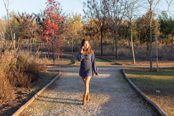 girl walking in the park while talking on her cell phone