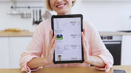 Happy Caucasian woman holding tablet displaying online cosmetics delivery website. Tablet screen shows various skincare products with prices and discounts, emphasizing convenient shopping experience.