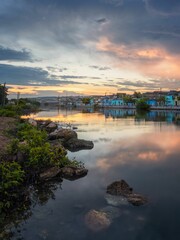 Naklejka premium Tranquil river at sunset with colorful reflections.