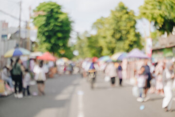 Blurry image of a crowded and lively street with people walking on a car free day.