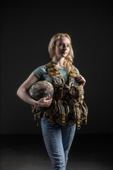Woman in Tactical Gear Holding a Military Helmet