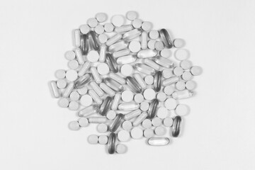 colorless medical tablets and pills, vitamins on white background. black and white medicines