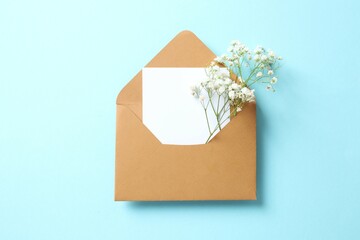 Top view photo with gypsophila flowers and paper envelope on color background 