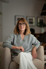 Portrait of smiling woman sitting in an armchair