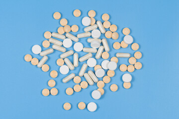 medical tablets and pills, vitamins on a blue background. medicines
