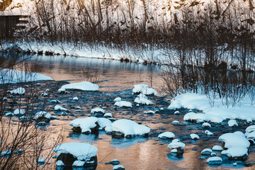 Serene Winter River Scene with Snow-Covered Rocks and Icy Banks Reflecting Tranquil Waters in a Beautiful Snowy Landscape During the Cold Season