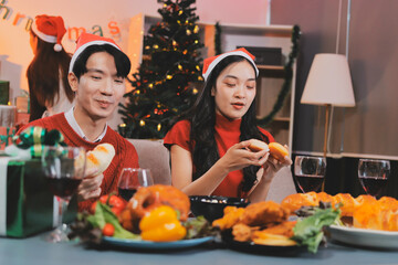 Group of young Asian man and women as friends having fun at a New Year's celebration, holding gift...