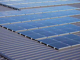 日本の工場の屋根に設置されたたくさんの太陽光発電パネルの風景