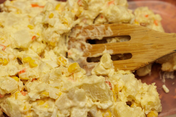 Creamy potato salad with corn and carrots, ready to serve.