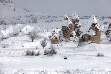 Safari trip ATV quad bike with fairy chimneys adorned with snow in the Cappadocia Göreme Turkiye poster.