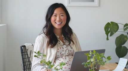 Asian pregnant woman with a big bump working remotely at a desk at home, displaying multitasking, dedication, and maternal strength. Woman managing work and pregnancy with grace