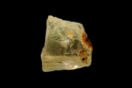 Natural rough honey-yellow Scapolite gemstone on dark background (Silicate group minerals) (selective focus)