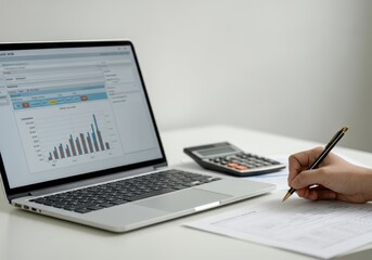 Businesswoman analyzing statistics charts showing financial growth on laptop and taking notes