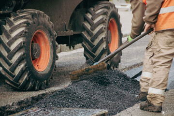 ouvrier en train de refaire le bitume d'une route, travaux de voirie