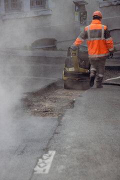 ouvrier en train de refaire le bitume d'une route, travaux de voirie