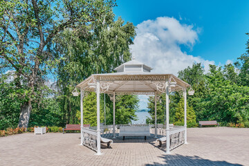 Picturesque white gazebo on square in summer Strukovsky Garden, Samara, Russia.