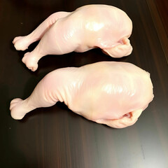 Fototapeta premium Raw uncooked chicken legs arranged on a dark wooden surface,