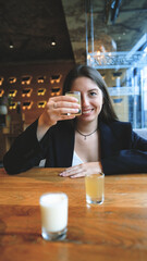 A woman clinks glasses and drinks an alcoholic tincture - close-up