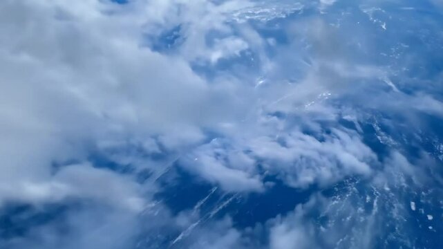 POV falling through clouds toward Earth ocean