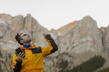 A man in a yellow jacket is pointing at something in the distance