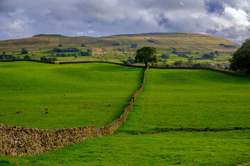 Sunshine through the rain clouds in the landscape near Hawes in Wensleydale, Yorkshire, UK