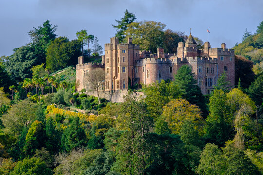 Signs of autumn colour in the trees around Dunster Castle, Somerset, UK