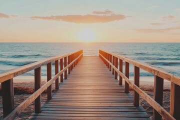 Fototapeta premium Wooden boardwalk extends to tranquil ocean at sunset. Perfect for travel, vacation, and serenity themes.