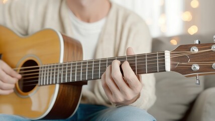 A person playing an acoustic guitar, showcasing a cozy indoor setting with soft lighting and a relaxed atmosphere.