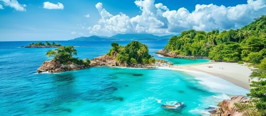 Fototapeta premium Crystal-clear turquoise water gently laps against the shore of a tropical island paradise, surrounded by lush green vegetation and a vibrant blue sky