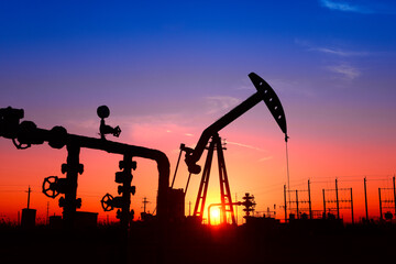 The pumping unit is working, in the silhouette of sunset