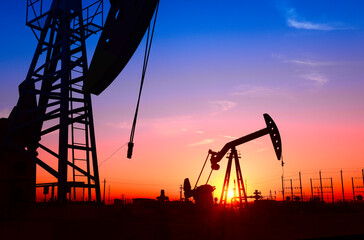 The pumping unit is working, in the silhouette of sunset