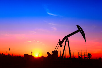 The pumping unit is working, in the silhouette of sunset