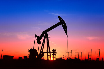 The pumping unit is working, in the silhouette of sunset