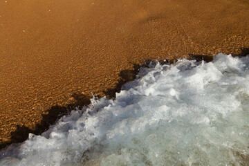 Soft sea wave rolls onto sandy beach. Red Sea. Copy space.