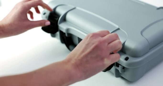 A gray protective case is illustrated being unlocked, making it an ideal option for securing valuable equipment safely
