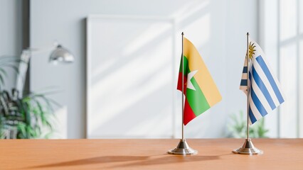 FLAGS OF MYANMAR AND URUGUAY ON TABLE